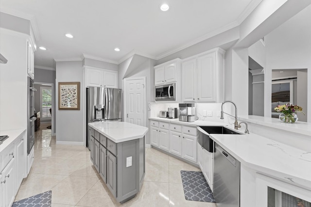 kitchen featuring white cabinets, a sink, stainless steel appliances, recessed lighting, and ornamental molding