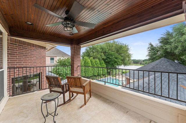 balcony featuring a ceiling fan and a water view
