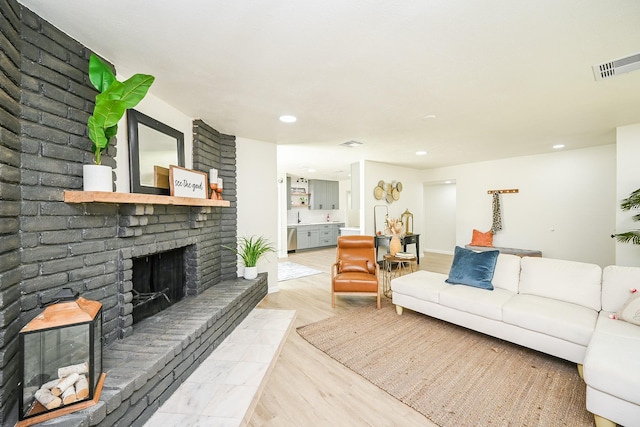 living area featuring wood finished floors, visible vents, a fireplace, and recessed lighting