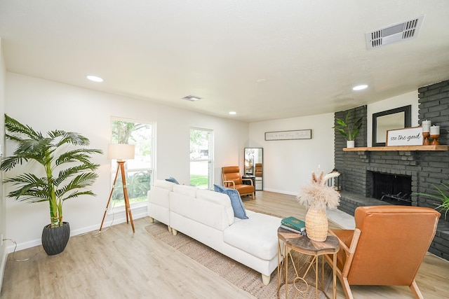 living room featuring a fireplace, wood finished floors, and visible vents