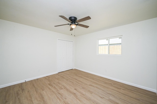 empty room featuring ceiling fan, baseboards, and light wood-style floors