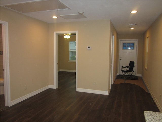 corridor with attic access, baseboards, dark wood-type flooring, and recessed lighting