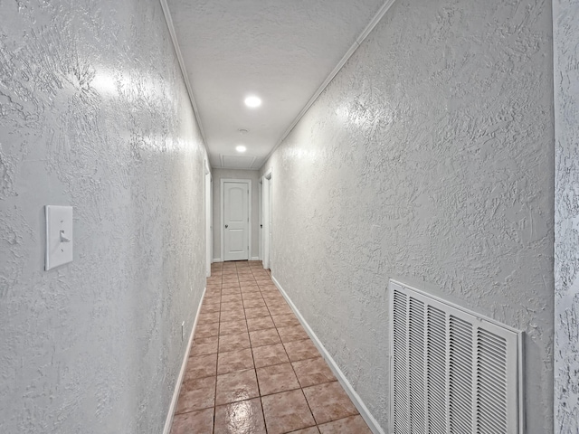 hall featuring recessed lighting, tile patterned floors, a textured wall, visible vents, and attic access