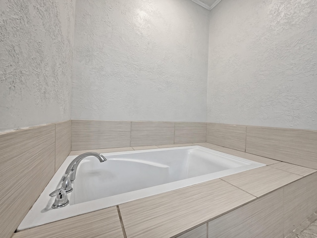 full bathroom featuring a textured wall and a garden tub