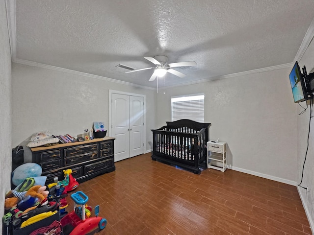 bedroom featuring wood finished floors, a textured ceiling, and ornamental molding