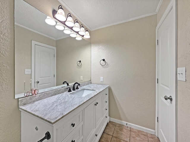 bathroom with baseboards, ornamental molding, vanity, and a textured wall