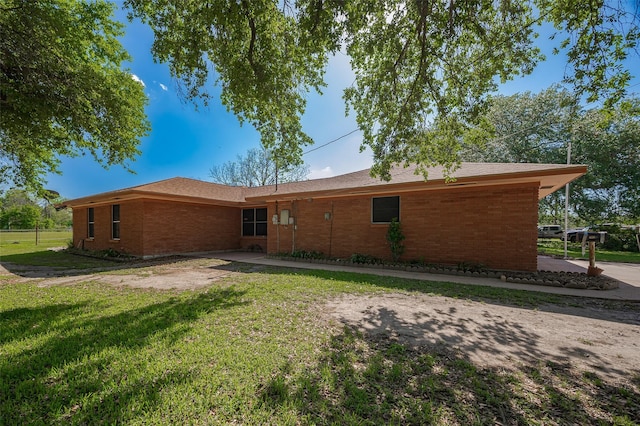 rear view of property with a lawn and brick siding