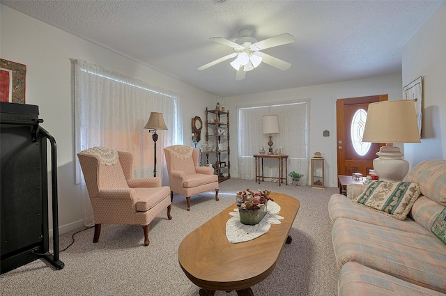 carpeted living area featuring a ceiling fan and a textured ceiling
