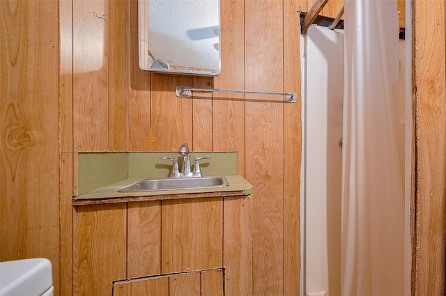 bathroom with wood walls, vanity, and toilet