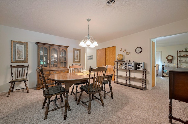 dining space featuring light colored carpet, a chandelier, and visible vents