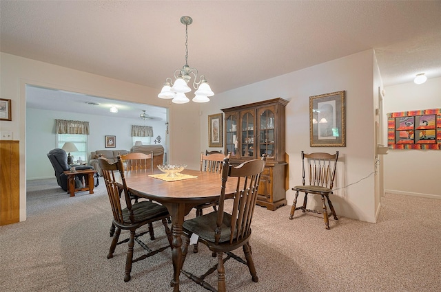 dining area featuring light carpet, baseboards, and a chandelier