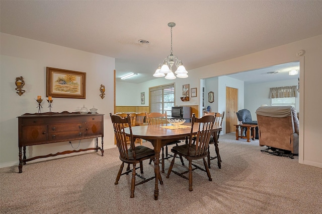 dining area with baseboards, a chandelier, and light colored carpet