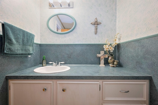 bathroom with vanity and wallpapered walls