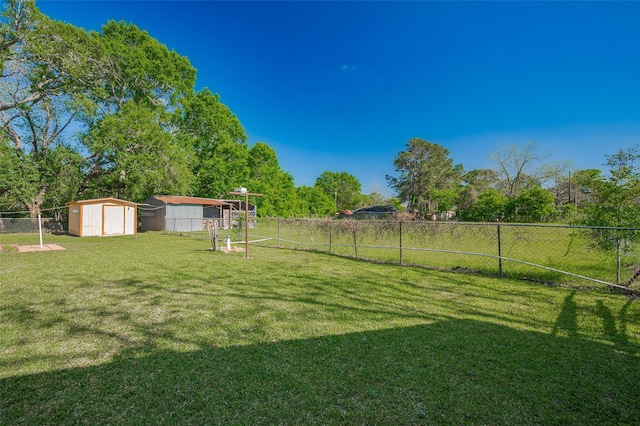view of yard featuring a storage unit, an outbuilding, and fence