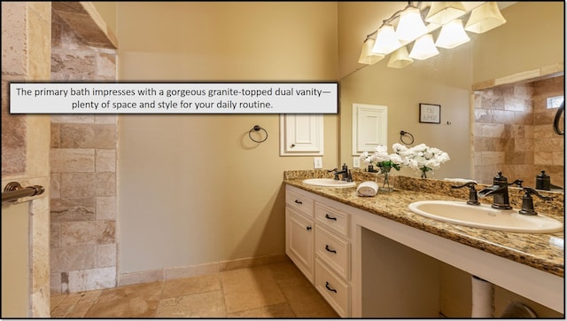 1814 S Everglades Dr, Deer Park, TX 77536 - bathroom featuring stone tile floors, double vanity, a tile shower, and baseboards