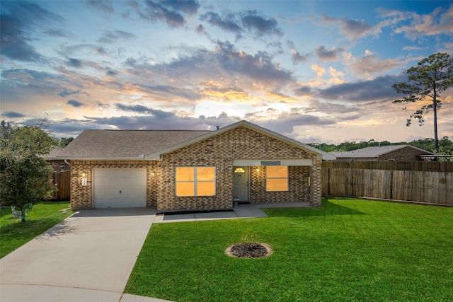 ranch-style home with a lawn, an attached garage, fence, and driveway