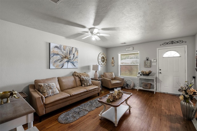living area featuring visible vents, wood finished floors, a textured ceiling, and ceiling fan
