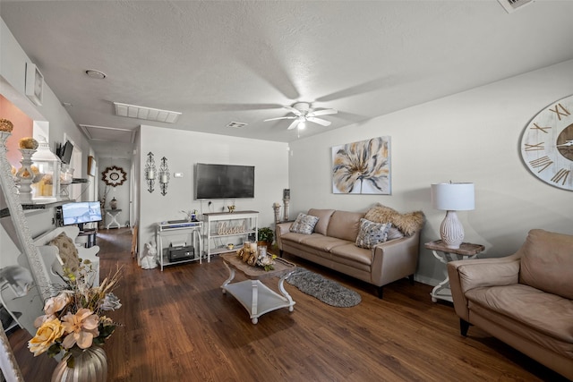 living room with wood finished floors, visible vents, and a ceiling fan