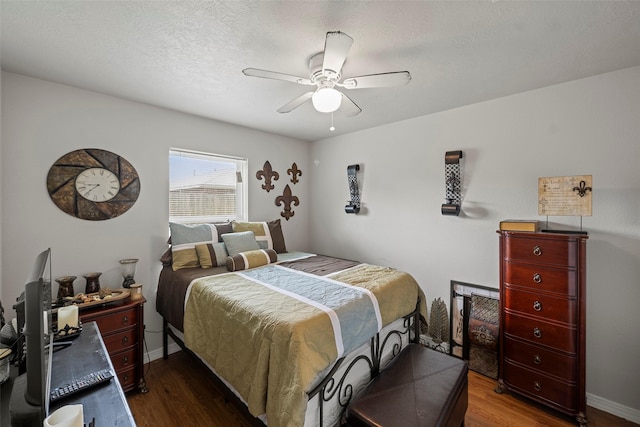 bedroom featuring baseboards, a ceiling fan, wood finished floors, and a textured ceiling