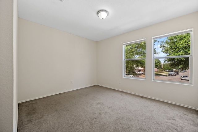 carpeted empty room featuring baseboards
