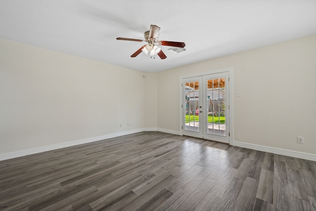 spare room with baseboards, ceiling fan, dark wood-style floors, visible vents, and french doors