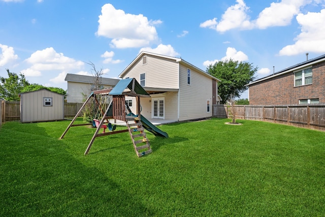 back of property featuring a fenced backyard, a lawn, a playground, a storage unit, and french doors