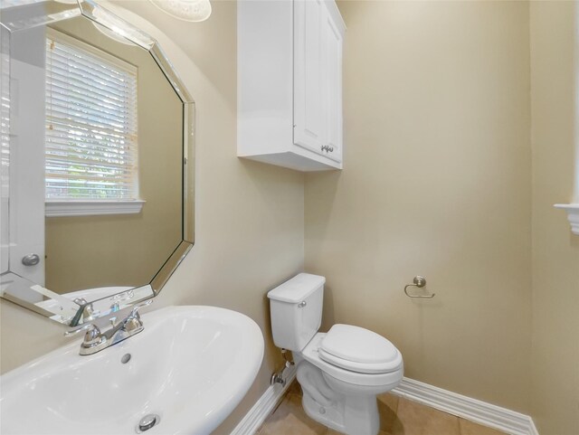 12620 Briar Patch Rd, Houston, TX 77077 - half bath featuring baseboards, toilet, tile patterned flooring, and a sink