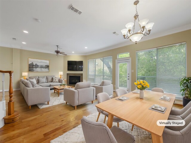 12620 Briar Patch Rd, Houston, TX 77077 - dining room featuring recessed lighting, visible vents, a fireplace, light wood-style flooring, and ceiling fan with notable chandelier