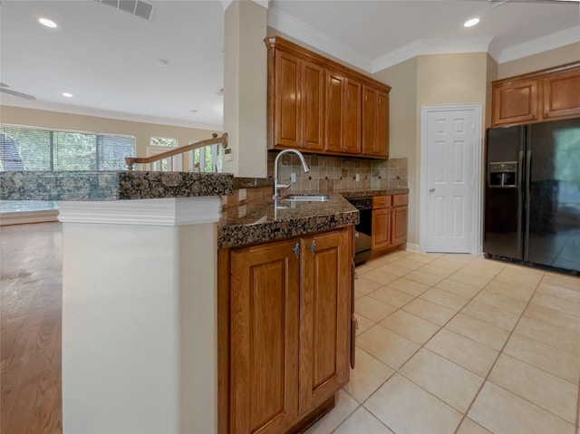 12620 Briar Patch Rd, Houston, TX 77077 - kitchen featuring a sink, brown cabinetry, black appliances, backsplash, and ornamental molding