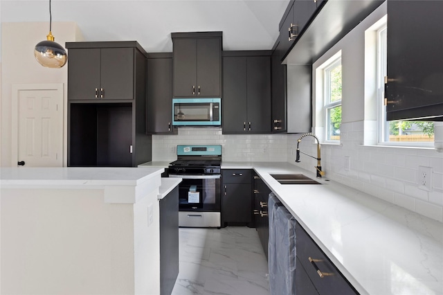 kitchen featuring tasteful backsplash, a sink, marble finish floor, pendant lighting, and stainless steel appliances