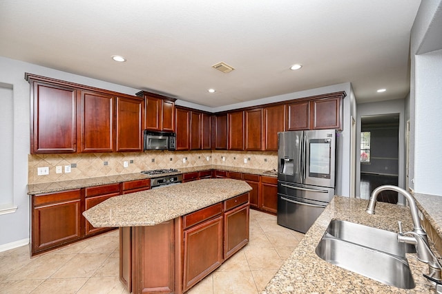 kitchen with decorative backsplash, a kitchen island, a sink, visible vents, and stainless steel refrigerator with ice dispenser