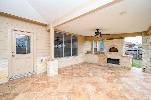 view of patio / terrace featuring fence, ceiling fan, and an outdoor stone fireplace
