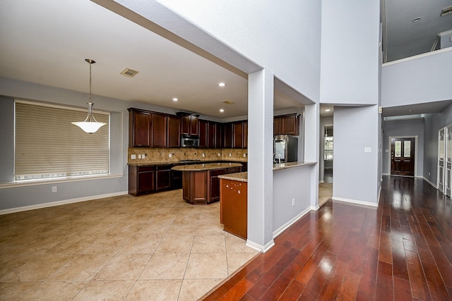 kitchen with baseboards, visible vents, appliances with stainless steel finishes, and light stone counters