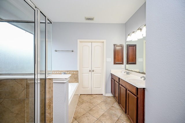 full bathroom with a sink, tile patterned floors, visible vents, double vanity, and a garden tub
