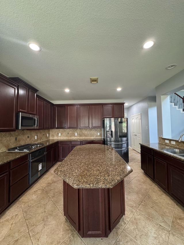 kitchen featuring appliances with stainless steel finishes, visible vents, backsplash, and a sink