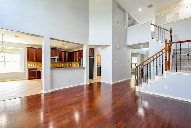 1106 Windsor Chase Ln, Spring, TX 77373 - unfurnished living room with a high ceiling, wood finished floors, stairway, and baseboards