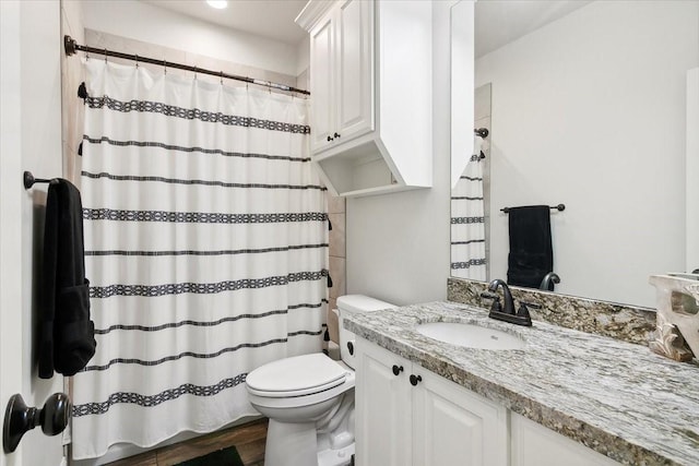 9345 Phelan Blvd, Beaumont, TX 77706 - full bath featuring wood finished floors, vanity, a shower with shower curtain, and toilet