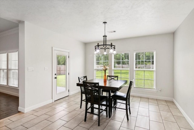 9345 Phelan Blvd, Beaumont, TX 77706 - dining area with a textured ceiling, visible vents, baseboards, and a notable chandelier
