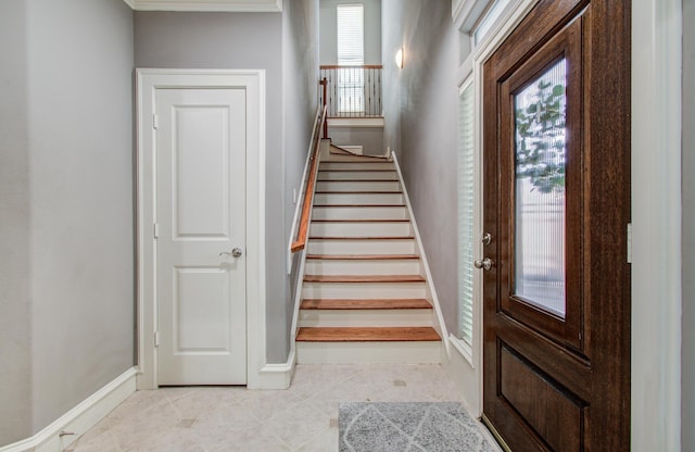 stairway with tile patterned floors and baseboards