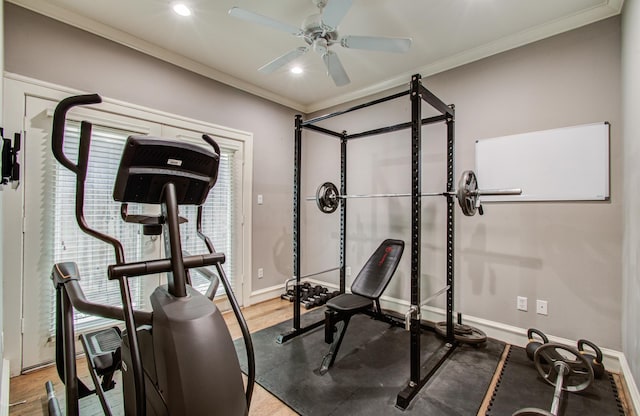 workout room featuring wood finished floors, baseboards, ceiling fan, and crown molding