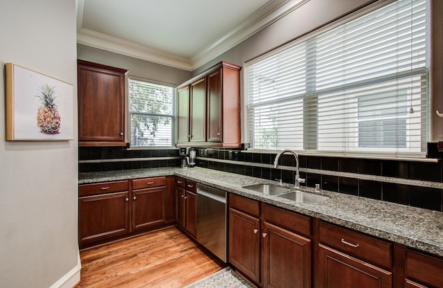 kitchen with dishwasher, dark stone counters, ornamental molding, and a sink