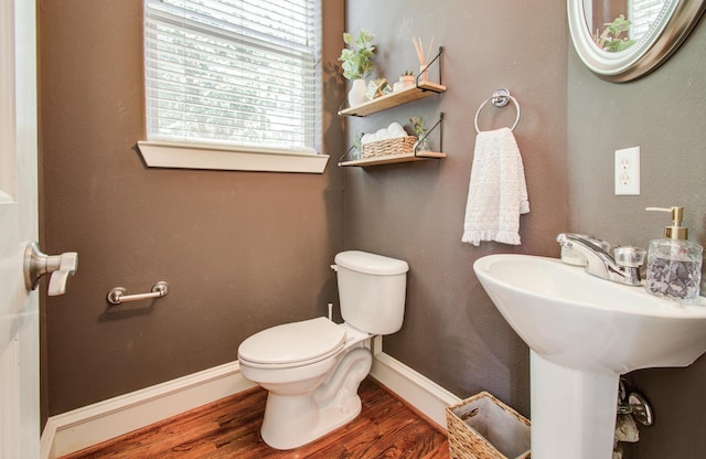 bathroom featuring toilet, wood finished floors, and baseboards
