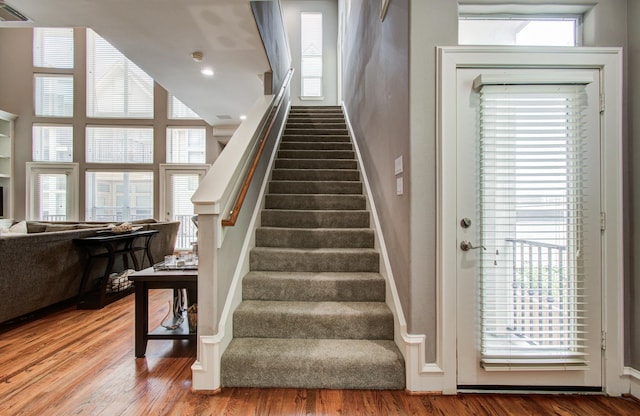 stairs featuring wood finished floors and visible vents