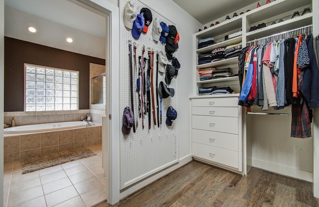 walk in closet with wood finished floors