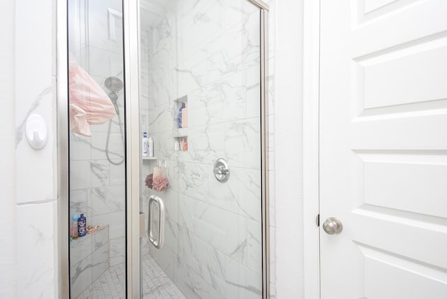 bathroom with a marble finish shower