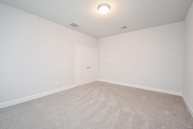 carpeted empty room with baseboards and visible vents