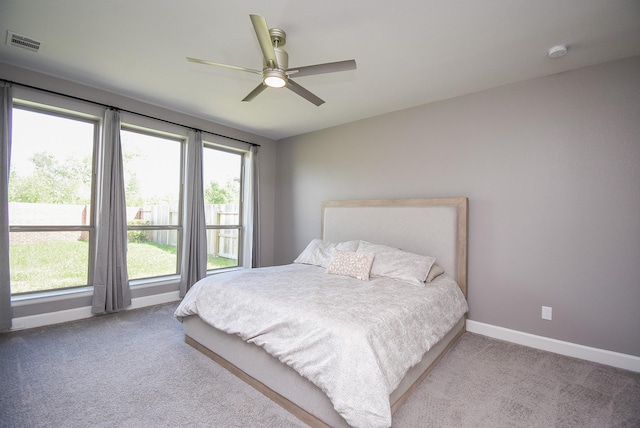 bedroom with carpet floors, visible vents, a ceiling fan, and baseboards