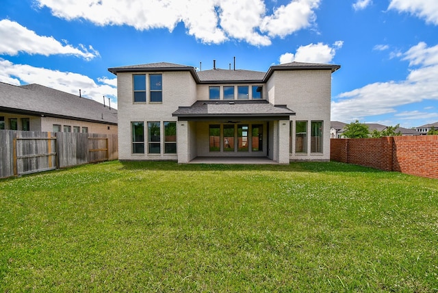 back of property featuring stucco siding, a lawn, a fenced backyard, and a patio