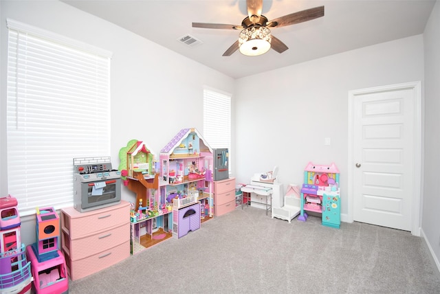 rec room featuring a ceiling fan, visible vents, and carpet