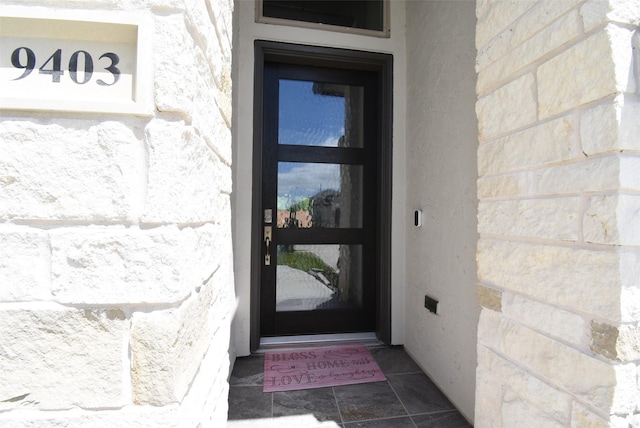 property entrance featuring stone siding